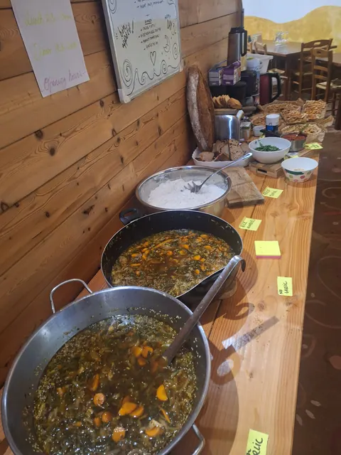 Deux grandes sauteuses de dahl et de curry posées sur le buffet en bois, étiquettes jaunes