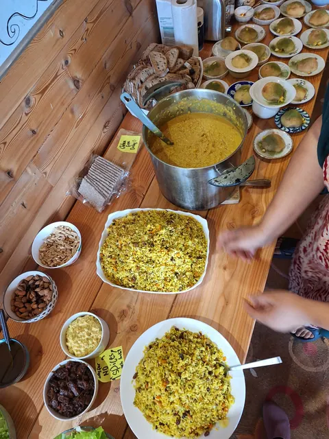 Le buffet du midi : marmite de curry, plats de riz jaune, bols de condiments