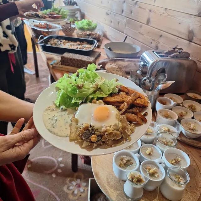 Assiette tendue : salade, frites de patate douce, oignons, sauce au yaourt et œuf, verrines de panna cotta à côté