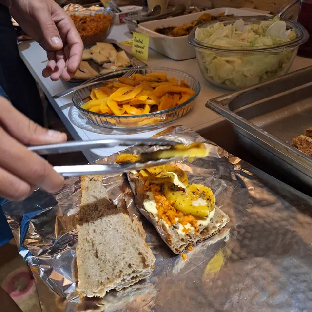 Une pince attrape une tartine de courge rôtie sur le buffet
