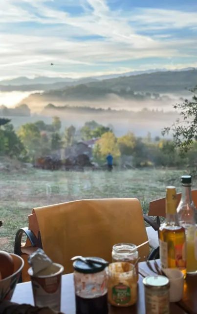 Bocaux sur une table en extérieur, vallée dans la brume du matin